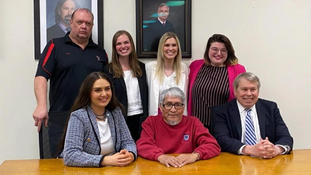 James Reyos, seated front center, next to Allison Clayton, left side, along with the other members of the Innocence Project of Texas team that got him exonerated for the murder of Father Patrick Ryan in Odessa in 1981.