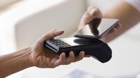 Female hand holding POS terminal, offering gadget for customer