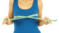 young woman is measuring her breast