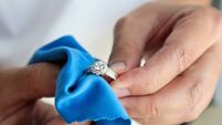 Jeweller hand polishing and cleaning jewelry diamond ring with micro fiber fabric
