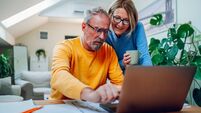 Senior middle aged happy couple using laptop together at home