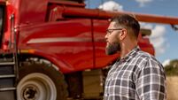 Portrait of agronomist in front of agricultural machine