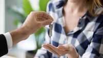 Young woman getting keys to new apartment from Real Estate Agent
