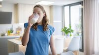 Teenage girl drinking a glass of milk at home