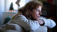 Lonely senior woman sitting on sofa indoors at Christmas, solitude concept.