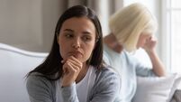 Annoyed selfish young woman ignoring unhappy mature mother after quarrel