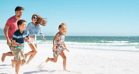 Happy family running on beach