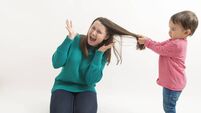 little girl pulls her older sister hair