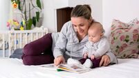 Young mother, reading a book to her baby boy, showing him pictures