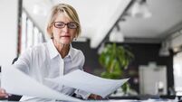Businesswoman examining documents at desk