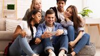 Teen guy showing new video on cellphone to friends