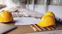 Construction helmets and blueprints on site