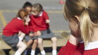 Young girl is whispered about in the school playground