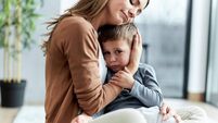 Loving mother consoling her sad son at home.