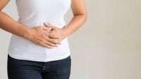 Young woman having painful stomachache. Chronic gastritis. Abdomen bloating concept.