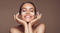 Beautiful woman applying cream on her face
