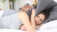 Man snoring and his wife covering ears