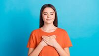 Photo portrait of lovely teen lady touch chest grateful dressed stylish orange garment isolated on blue color background