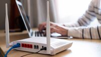 Selective focus at router. Internet router on working table with blurred man connect the cable at the background. Fast and high