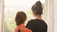 Mother and son looking out of window