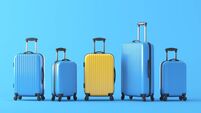 Yellow suitcase standing in terminal, full of blue suitcases