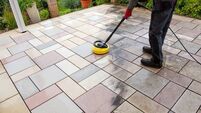 Cleaning stone slabs on patio with the high-pressure cleaner.