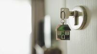 Open the door and door handle with a key and a keychain shaped house. Property investment and house mortgage financial real esta