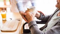 Unrecognizable health visitor and a senior woman during home visit.