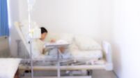 Blurred image of Patient with drip in hospital for background usage. Illness child in hospital, saline intravenous (IV) on hand