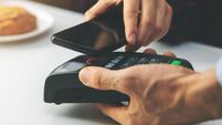 contactless payment - woman paying bill with smartphone at cafe