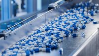 Blue Capsules on Conveyor at Modern Pharmaceutical Factory. Tablet and Capsule Manufacturing Process. Close-up Shot of Medical D