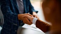 Close up of business people shaking hands in the office.