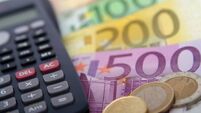 Close-up of a calculator and foreign paper money and coin