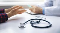 medical consultation - doctor talking to patient in clinic office. focus on stethoscope