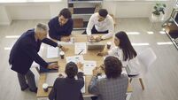 Business team analyzes sales charts and diagrams, develops a new strategy and discusses work issues.